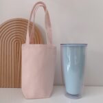 Taza de agua portátil Bolsa de café Aislamiento térmico al aire libre Cubierta de taza de lona de color sólido, Handheld (Light Pink)